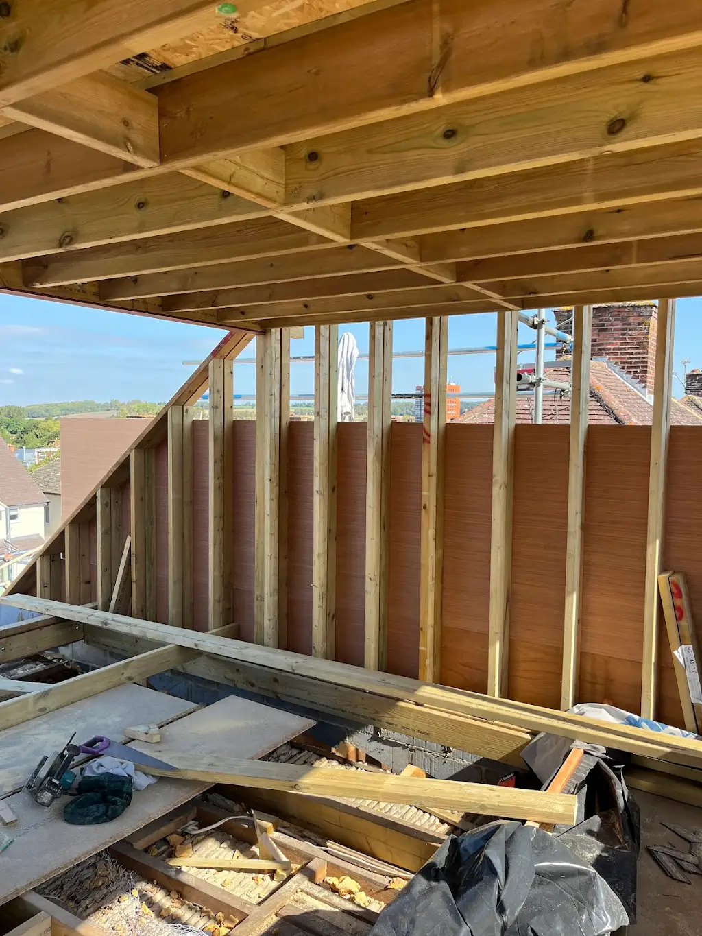 Inside the new dormer looking out, showing stud walls and ceiling joists