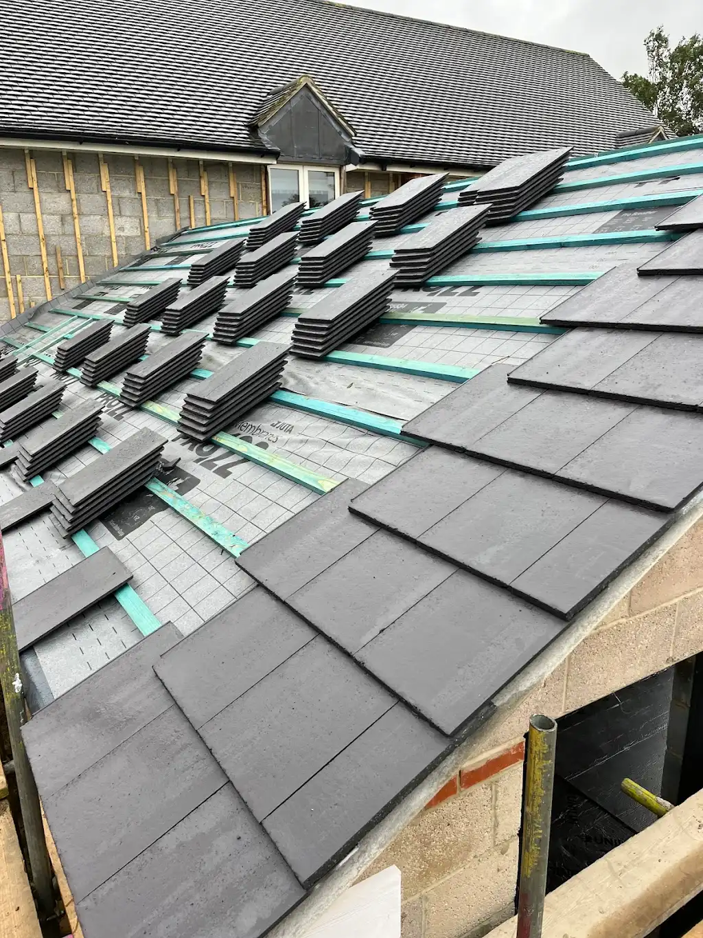 Tiles being loaded out across the second roof slope ready for laying