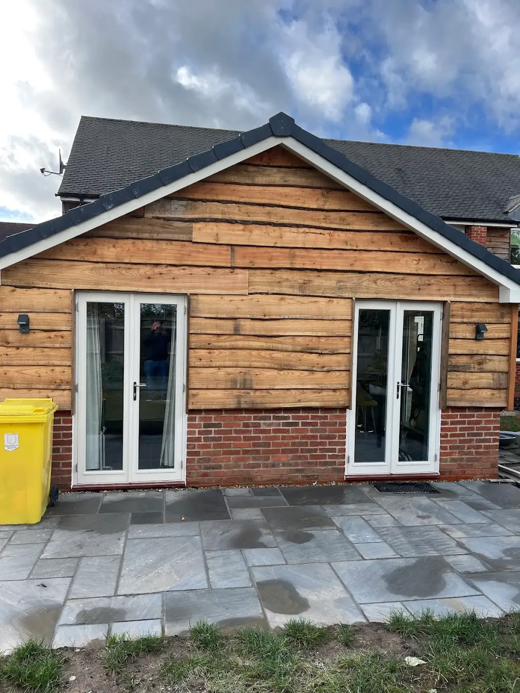 Gable end of the new extension with two sets of French doors and sandstone patio