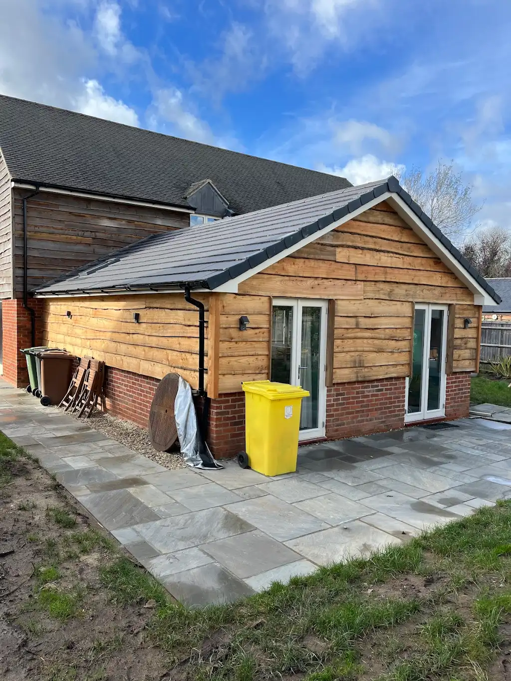 Side view of the timber-clad extension showing the pitched tile roof tying into the main house